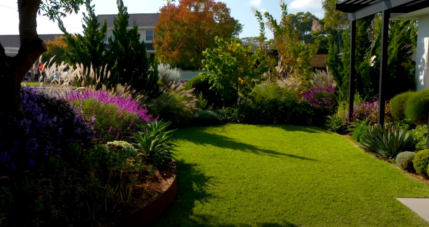 Beautifully landscaped curved lawn with colorful perennial borders
